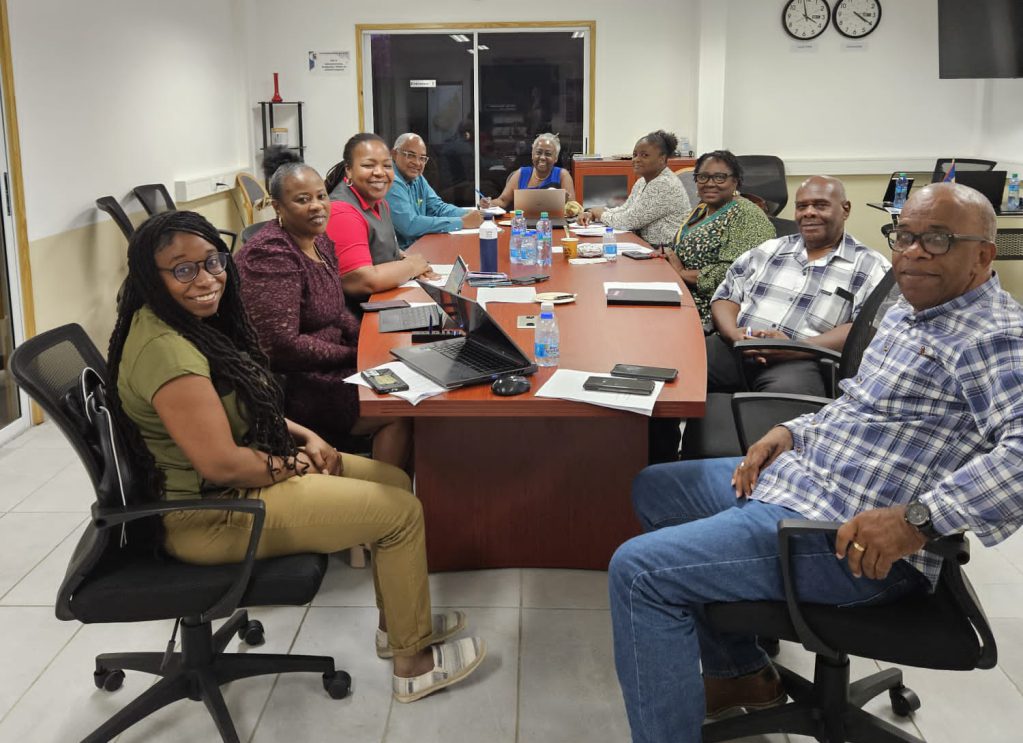 Raquel and Rechelline at the table with the island council on the immediate and third left, with Nilda at the head of the table.