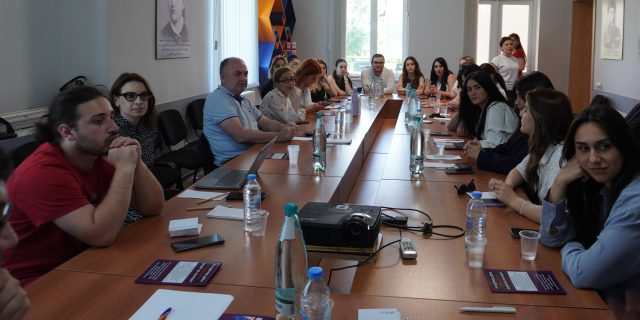 The participants sit around a big table.